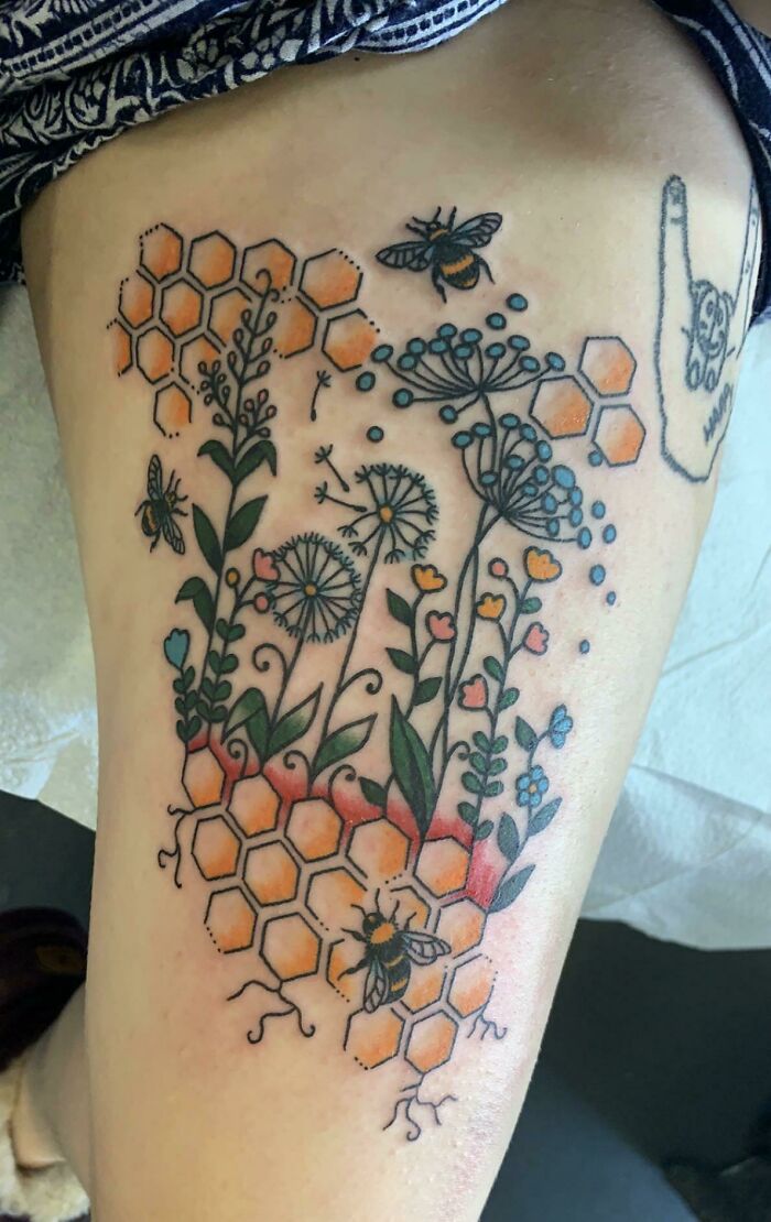 Nature tattoo featuring bees, flowers, and honeycomb design, celebrating the human-earth bond.