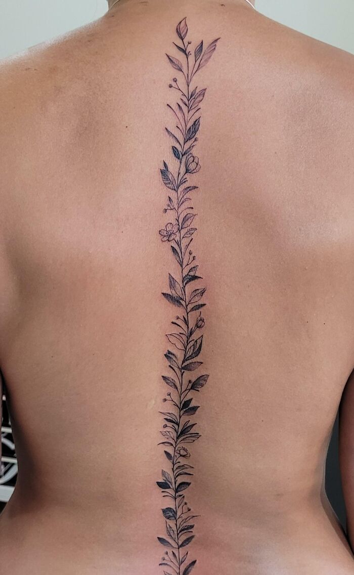 Elegant spine tattoo featuring a floral design down the back.