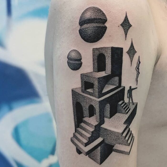 Optical illusion tattoo with geometric shapes, floating spheres, and a staircase design on an upper arm.