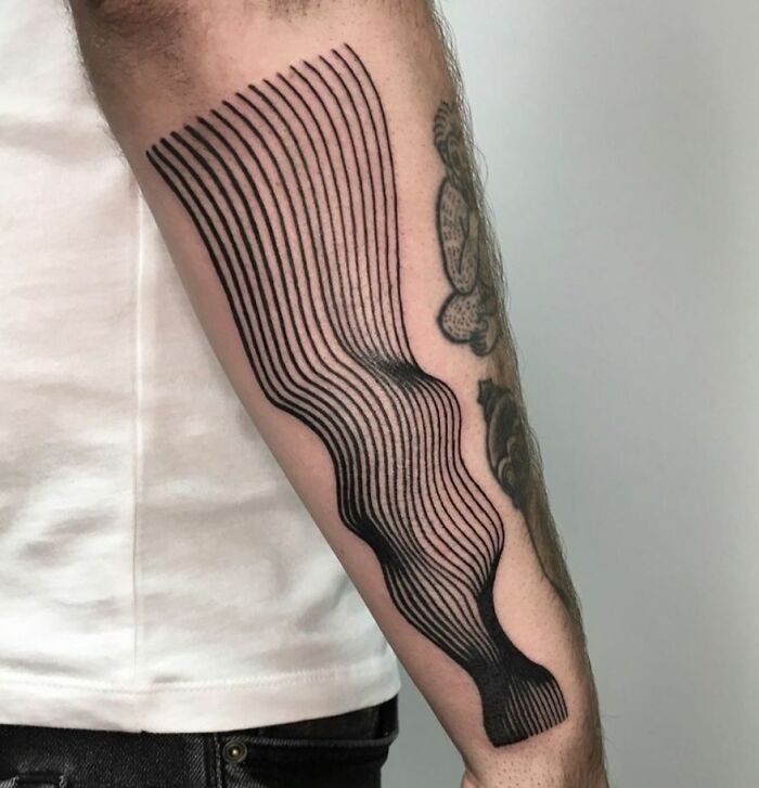 Optical illusion tattoo on arm featuring wavy lines creating a distorted, eye-catching design.