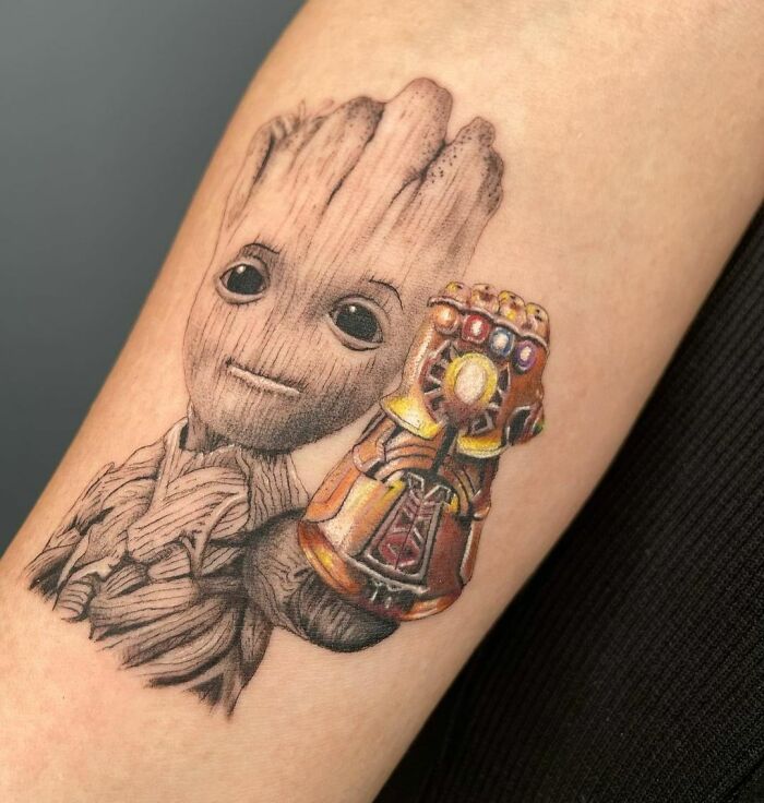 Marvel tattoo featuring Groot with an Infinity Gauntlet design on a person's arm.