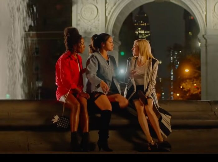 Three women sitting together at night near a city arch, exemplifying iconic friendship duos.