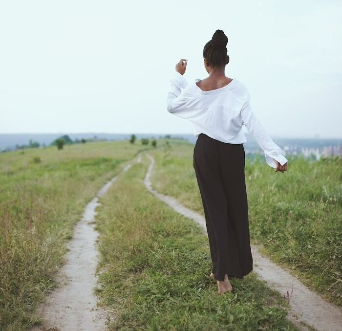 woman walking barefoot in the grass