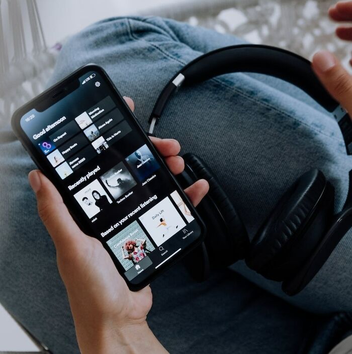 person choosing the song on his mobile phone