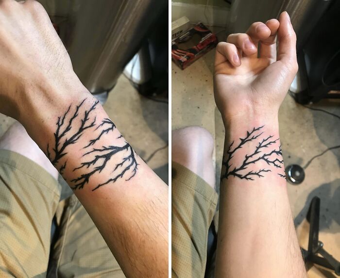 Minimalistic wrist tattoo featuring abstract black branches.