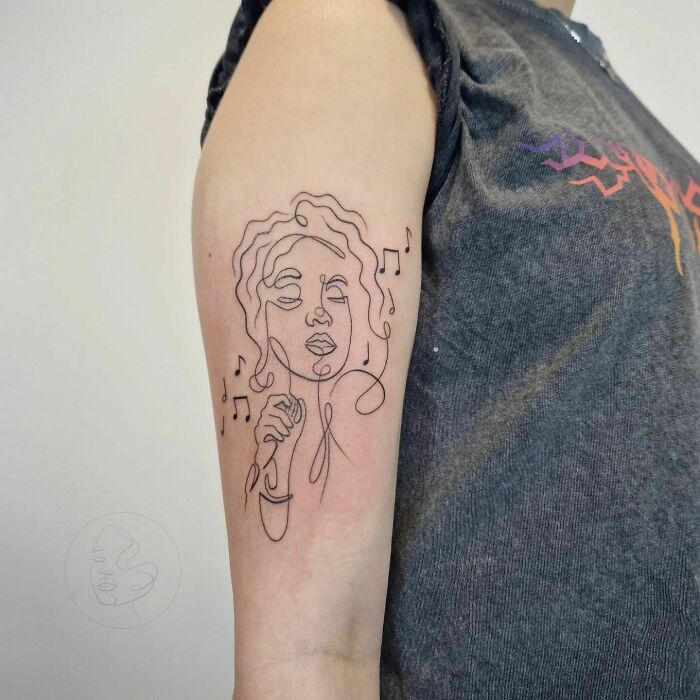 Line art music tattoo featuring a singer with music notes on an arm.