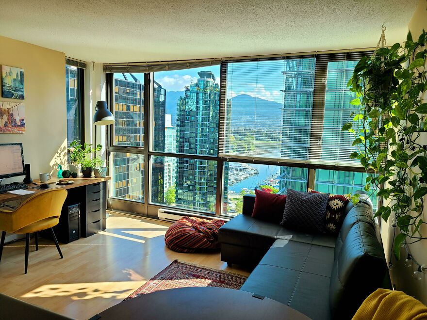 Living room with black couch and big windows 