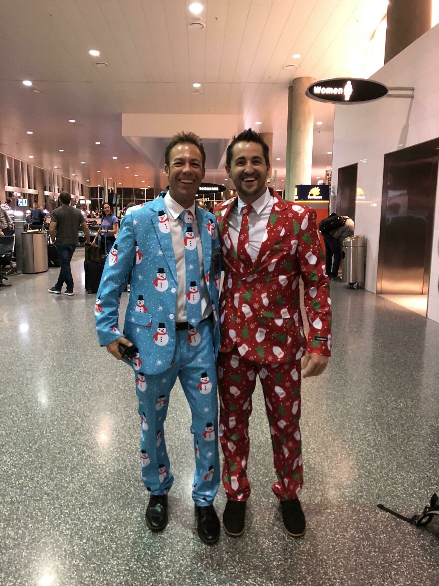 Two man with Christmas outfits hugging in the airport 