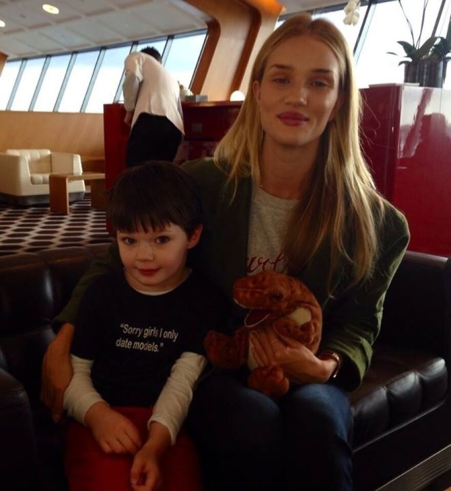 Little kid taking a picture with a famous model in an airport 