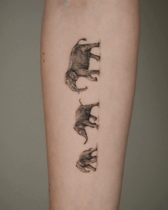 Tattoo of a family of elephants on skin, symbolizing unbreakable bonds.