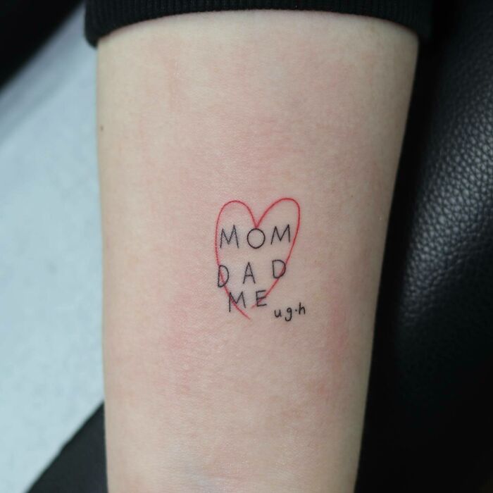 Family tattoo with "Mom, Dad, Me" text inside a red heart, symbolizing unbreakable bonds.
