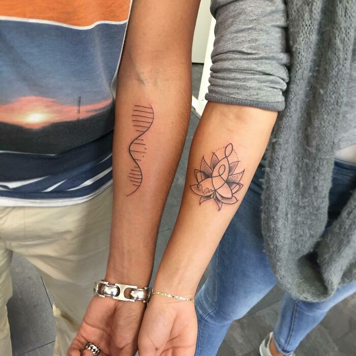 Two forearm tattoos symbolizing family bonds: one DNA strand and one lotus flower intertwined with infinity.