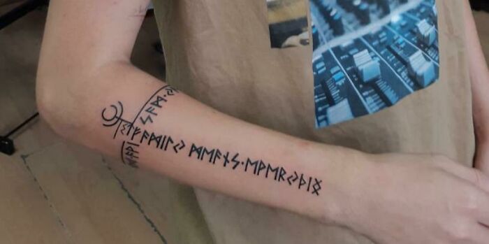 Arm tattoo in runic script symbolizing family bonds.