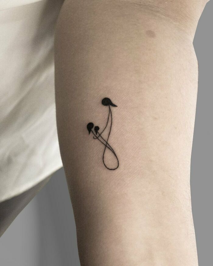 Minimalistic family tattoo symbolizing unbreakable bonds on inner arm.