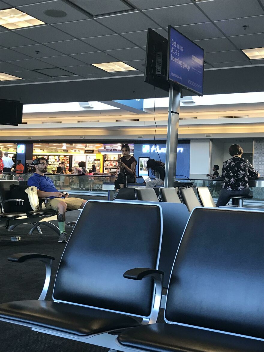 Man playing console games on an airport's tv