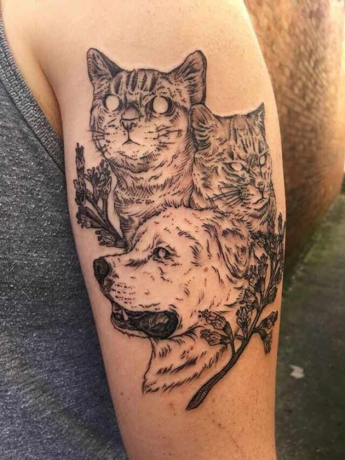 Tattoo of a cat and dog symbolizing family bonds on a person's arm, surrounded by floral elements.