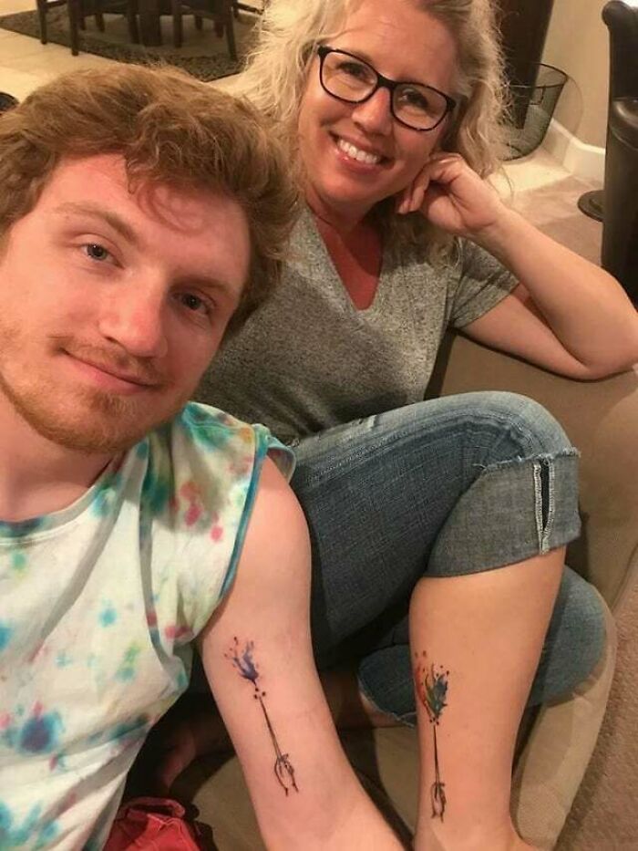 Mother and son showcasing matching arrow tattoos symbolizing family bonds.