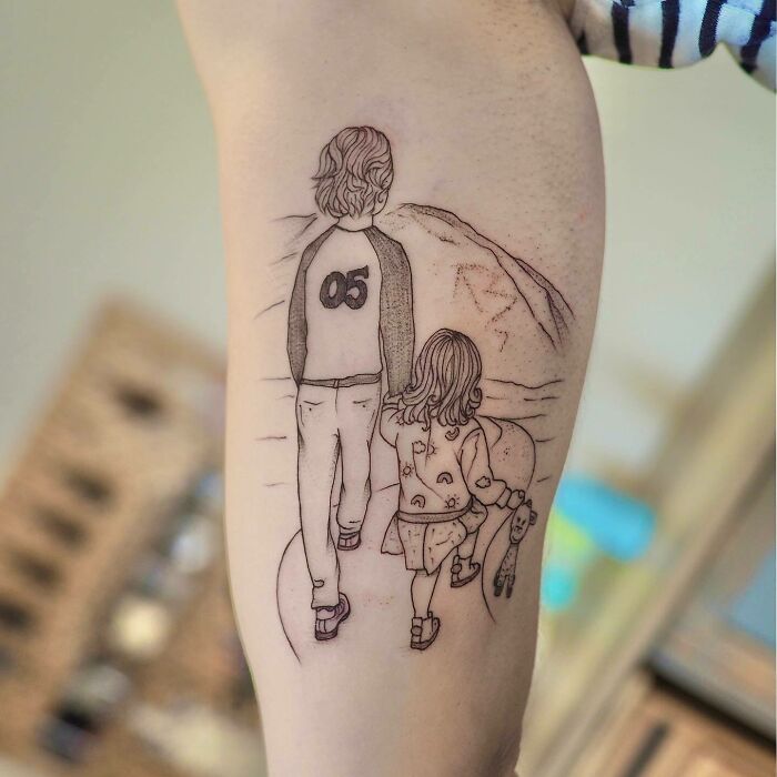 Family tattoo of a child and adult walking, symbolizing unbreakable bonds.