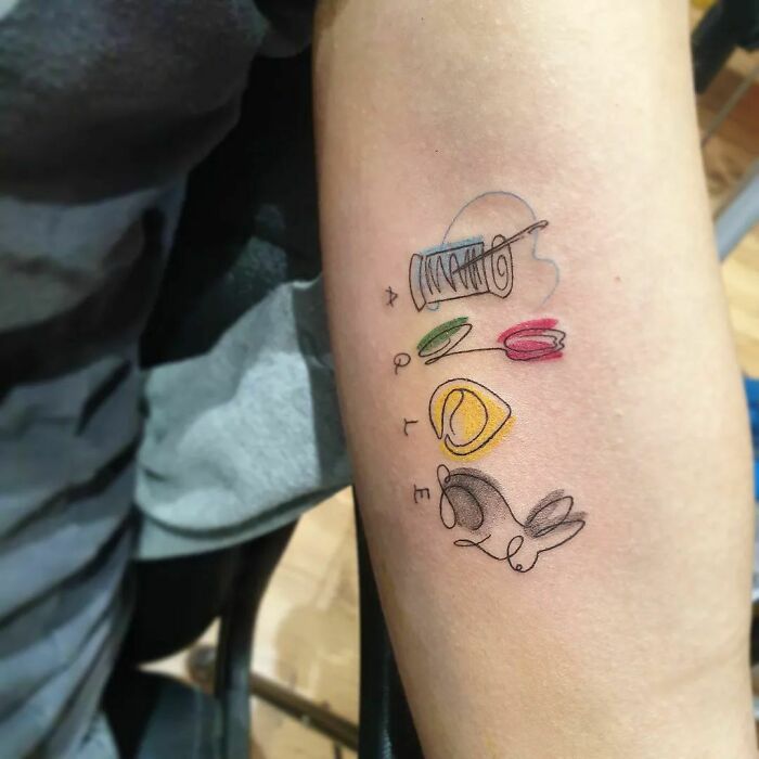 Minimalist family tattoo with vibrant colors, symbolizing unbreakable bonds on an arm.