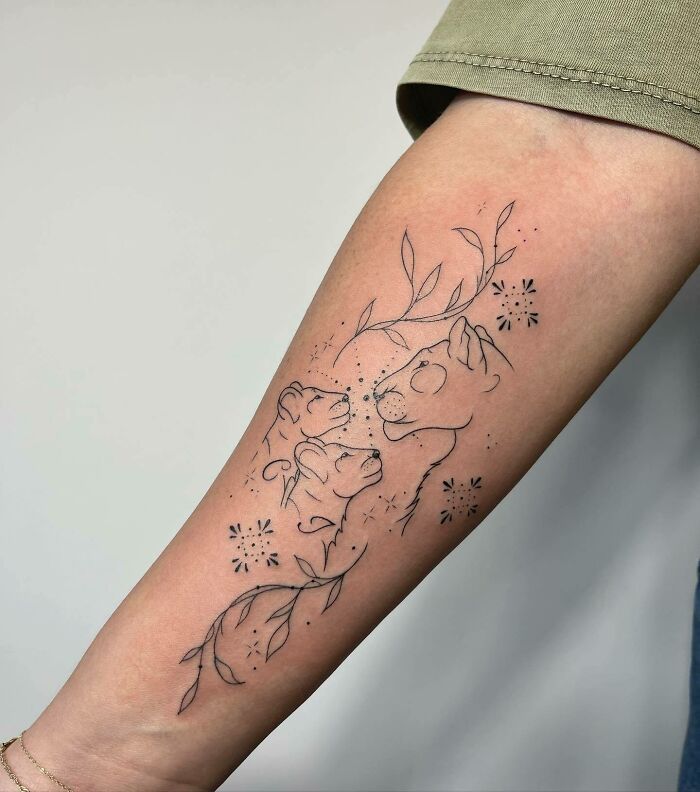Family tattoo featuring a lion pride, symbolizing unbreakable bonds, with floral accents on forearm.