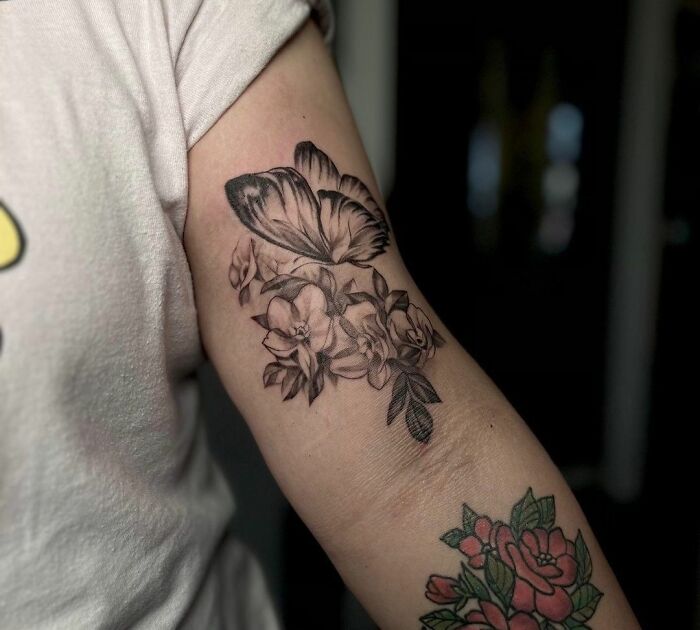 Butterfly and floral nature tattoo on a person's arm, celebrating the wonders of Mother Earth.