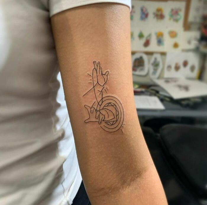 Line art Marvel tattoo of a hand on an arm.