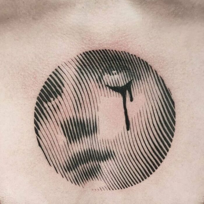 Optical illusion tattoo featuring a circular design with intricate shading and line details.