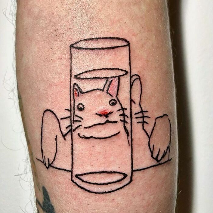 Optical illusion tattoo of a cat appearing behind a transparent glass on skin.