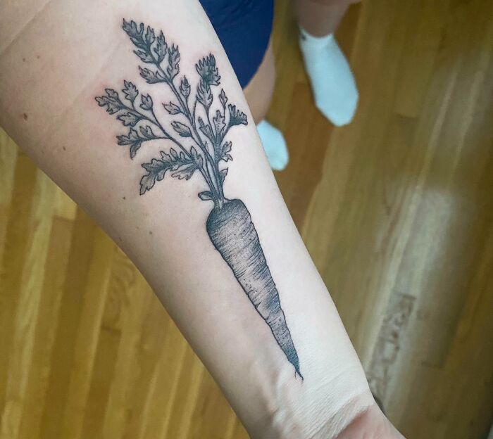 Black and white carrot tattoo on forearm, showcasing food tattoo inspiration.
