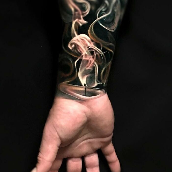Forearm tattoo with optical illusion of smoke swirling from a candle, creating a surreal visual effect.