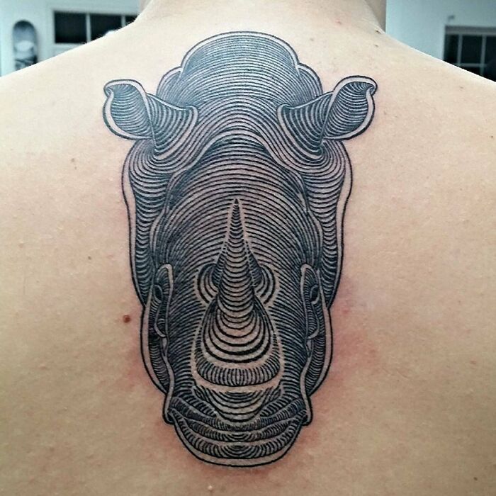 Optical illusion tattoo of a rhino on a person's back, creating a layered, textured visual effect.
