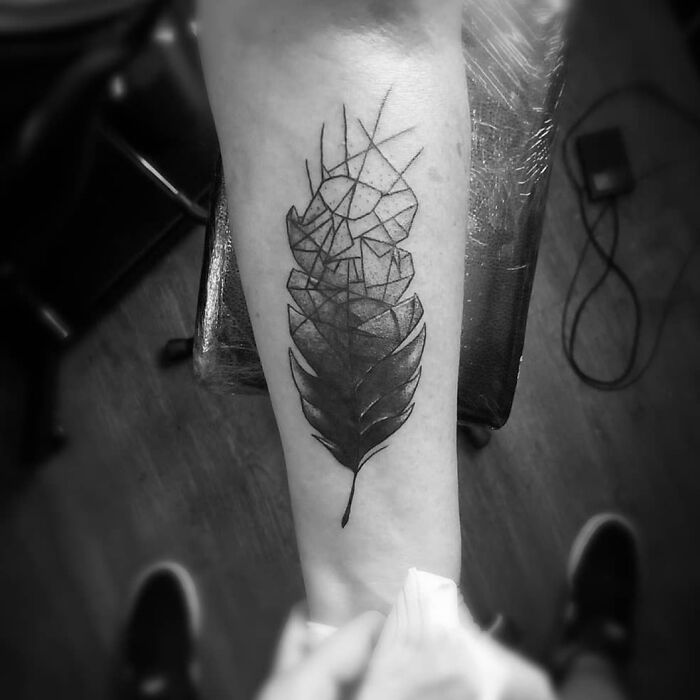 Optical illusion tattoo of a leaf on an arm, blending geometric shapes with natural elements.