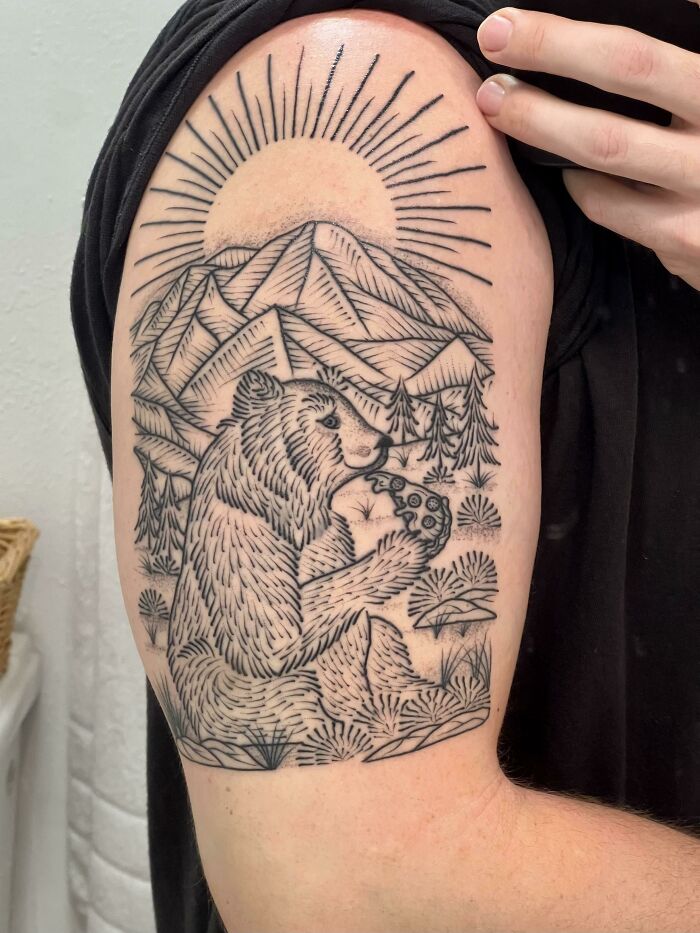 Bear eating pizza tattoo with sun and mountain background, showcasing a unique food tattoo design.