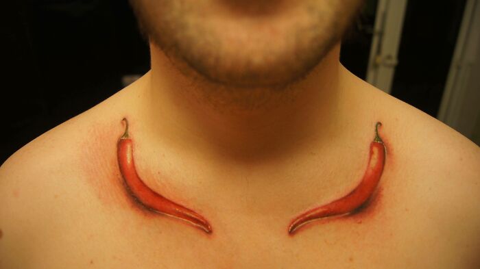 Watercolor tattoo of red peppers on person's chest, showcasing creative food tattoo ideas.