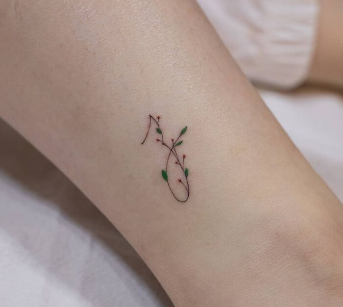 Delicate mom tattoo with floral design on forearm, symbolizing mother-child bond.