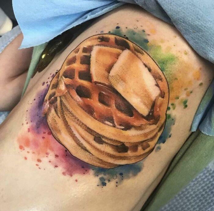 Food tattoo of waffles with butter, featuring vibrant colors in a watercolor style.
