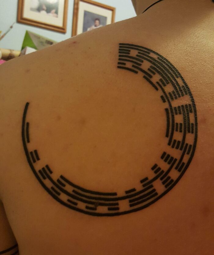 Circular tribal mom tattoo on shoulder, symbolizing the mother-child bond.