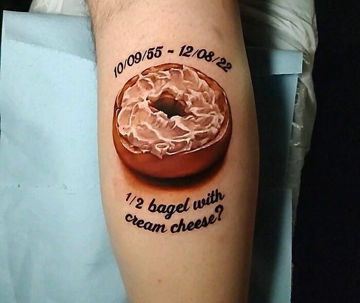 Food tattoo of a bagel with cream cheese on a leg, featuring dates.