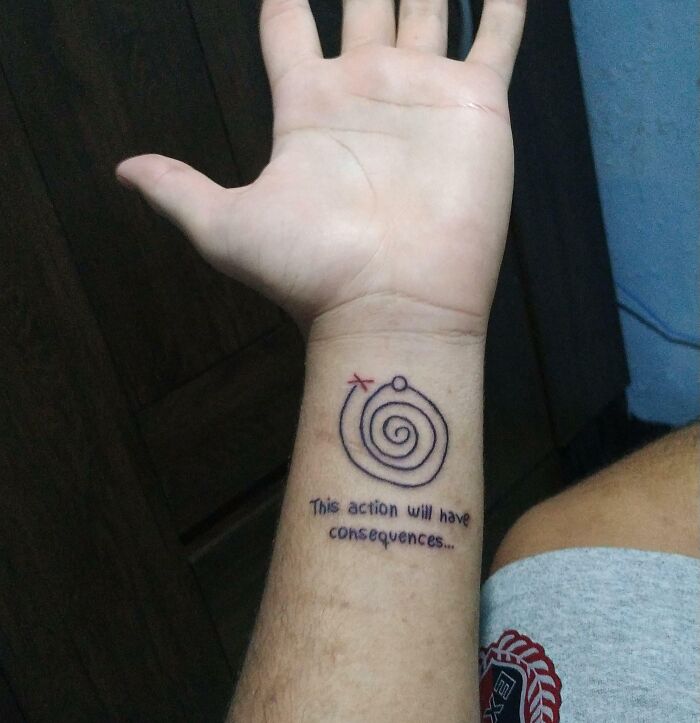 Wrist tattoo featuring a spiral design with text "This action will have consequences."