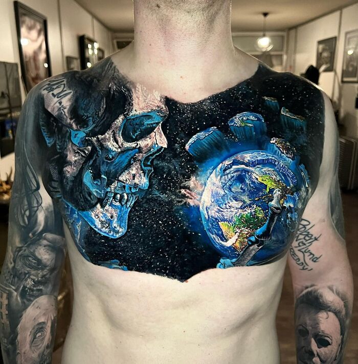 Chest tattoo with a cosmic skull and Earth, showcasing advanced tattoo art in vivid detail.