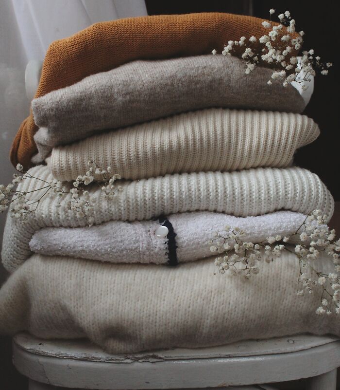 Multiple sweaters and blankets laying on top of each other 