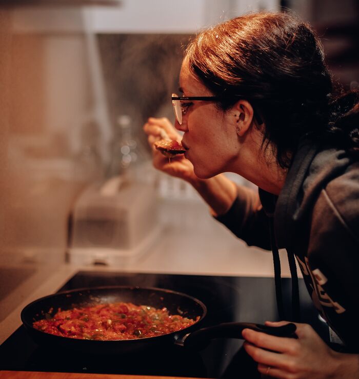 Woman Tasting Food In The Process Of Making It 