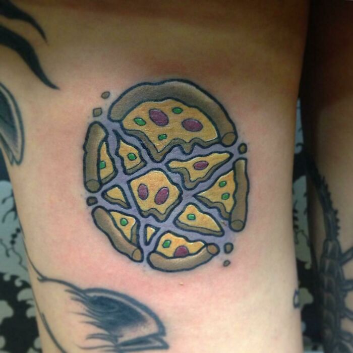 Pizza tattoo on arm, featuring slices and toppings, showcasing delicious food art.