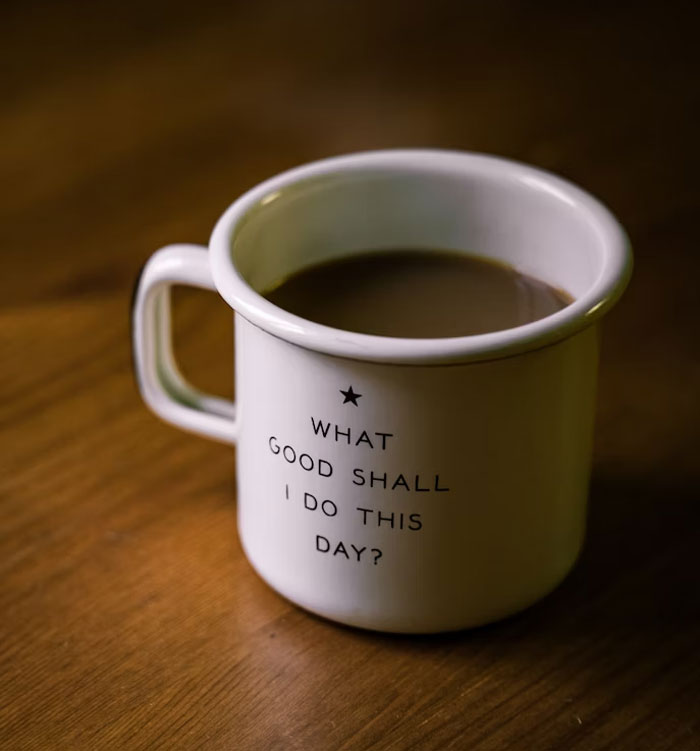 White coffee mug with inspirational quote on a wooden table, reflecting advice from people over the age of 50.