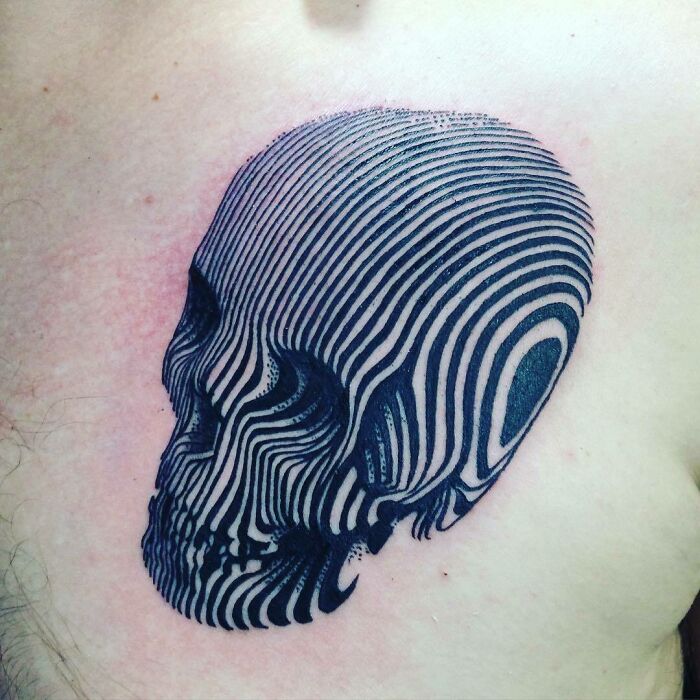 Optical illusion tattoo of a skull with intricate black stripes.