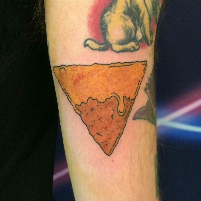 Pizza slice tattoo on an arm, showcasing delicious food ink design.