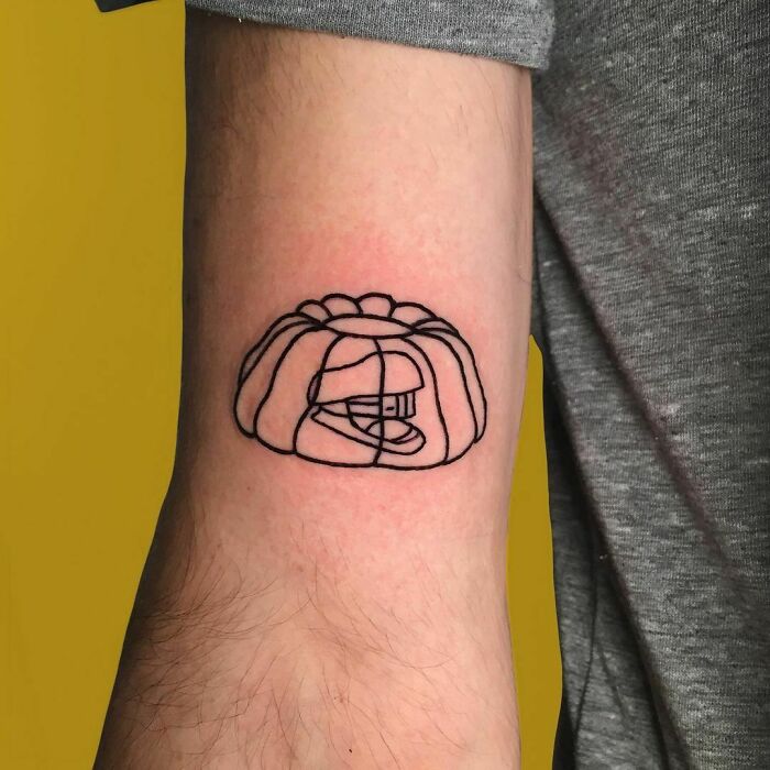 Minimalistic tattoo of a stapler in jello, showcasing a unique food-inspired design on the arm.