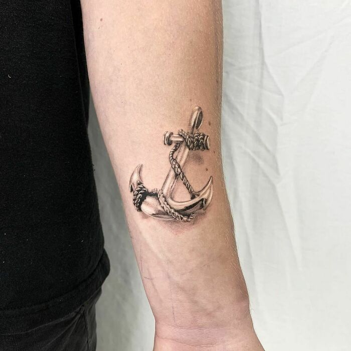 Anchor wrist tattoo design on forearm, showcasing intricate details and bold lines.