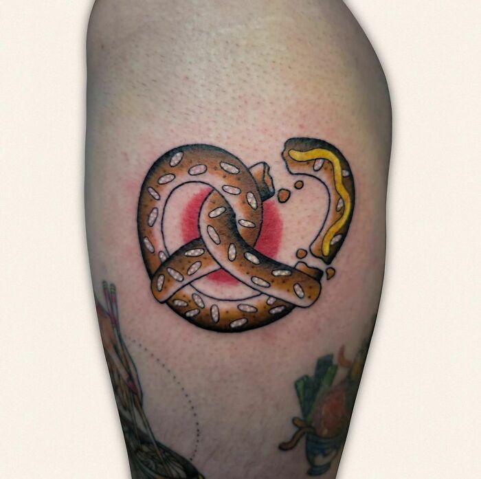 Watercolor tattoo of a pretzel, showcasing food ink-spiration on skin.