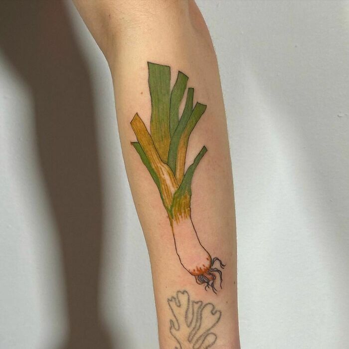 Food tattoo of a colorful leek on a person's forearm depicting a unique ink design.